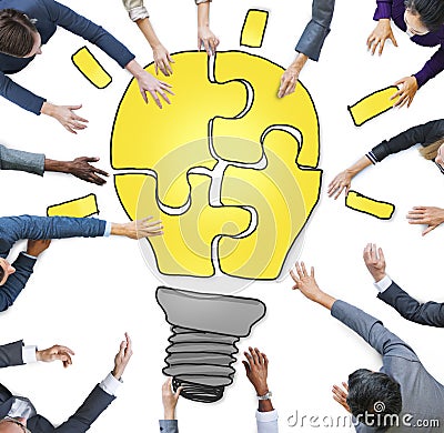 Business People Forming a Light Bulb Puzzle Stock Photo