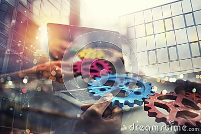 Business people with gears in hand that exit from a laptop. concept of remote cooperation and teamwork. Double exposure Stock Photo