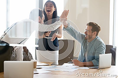 Business people giving high five, excited colleagues celebrating success Stock Photo