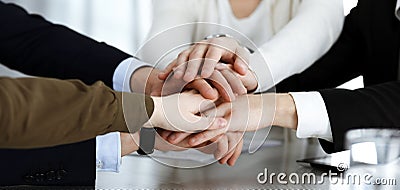 Business people group showing teamwork and joining hands or giving five in modern office. Unknown businessman and women Stock Photo