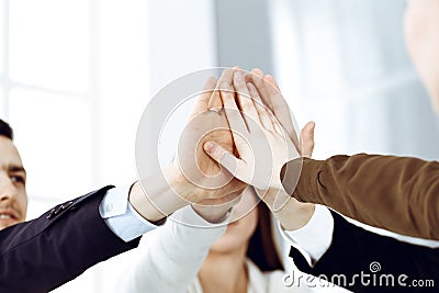 Business people group showing teamwork and joining hands or giving five in modern office. Unknown businessman and women Stock Photo