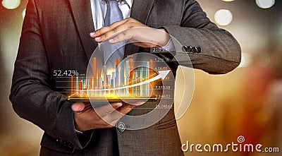 Business people hold a tablet, plan and strategy and display virtual holograms of statistics, financial graphs, securities and Stock Photo