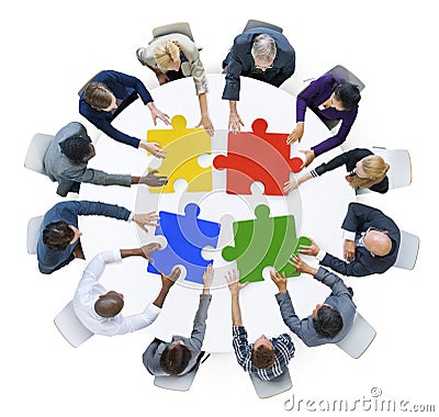 Business People with Jigsaw Puzzle and Teamwork Concept Stock Photo