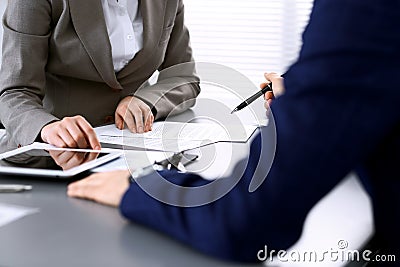 Business people and lawyer discussing contract papers sitting at the table, hands close-up. Teamwork or group operations Stock Photo