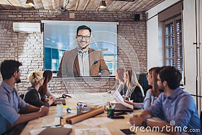 Business people looking at projector during video conference Stock Photo