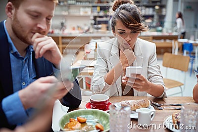Business people at lunch, not talking, worried, after covid, distracted from each other by cell phones. issues, recessions, Stock Photo
