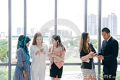 Business People Meeting Discussion Working and talking in office. Young people using smart phones at workplace. Stock Photo