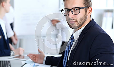 Business people at meeting in office. Focus at cheerful smiling bearded man wearing glasses. Conference, corporate Stock Photo