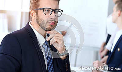 Business people at meeting in office. Focus at cheerful smiling bearded man wearing glasses. Conference, corporate Stock Photo