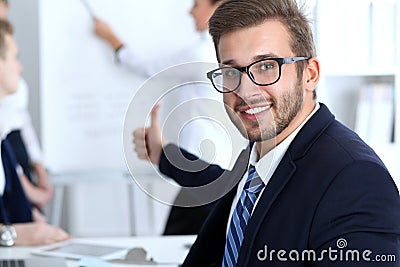 Business people at meeting in office. Focus at cheerful smiling bearded man wearing glasses. Conference, corporate Stock Photo