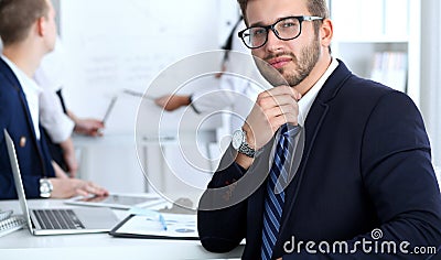 Business people at meeting in office. Focus at cheerful smiling bearded man wearing glasses. Conference, corporate Stock Photo