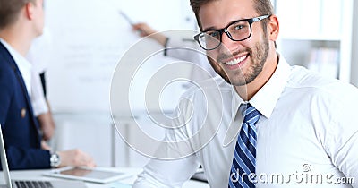 Business people at meeting in office. Focus at cheerful smiling bearded man wearing glasses. Conference, corporate Stock Photo