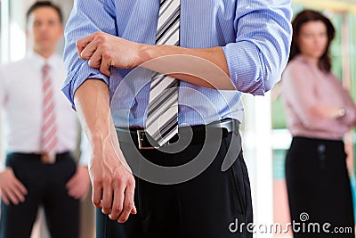 Business and people - roll up the sleeves Stock Photo