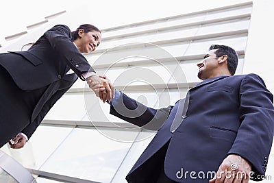 Business people shaking hands outside office Stock Photo