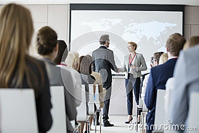 Business people shaking hands during seminar at convention center Stock Photo