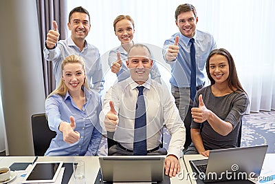 Business people showing thumbs up in office Stock Photo