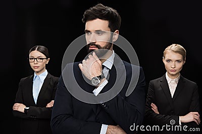 Business people standing with crossed arms isolated on black, business establishment concept Stock Photo