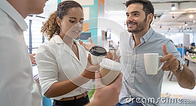 Business people talking and holding cups of coffee .Group of coworkers having a coffee break in office. Stock Photo