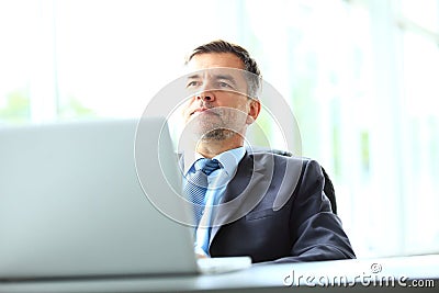 Business, people and technology concept - happy smiling businessman with laptop computer office Stock Photo