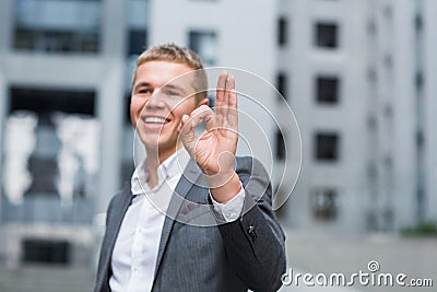 Business, people, vision and success concept - happy smiling businessman in eyeglasses and suit showing ok sign over office buildi Stock Photo