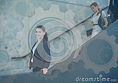 Business people walking down stairs with gear graphics overlay Stock Photo