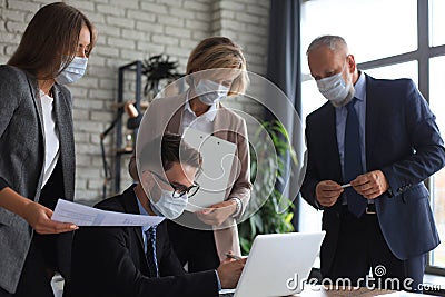 Business people wearing protective face masks while holding a presentation on a meeting during coronavirus epidemic Stock Photo