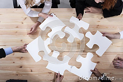 Business people work together to build a puzzle. Concept of teamwork, partnership, integration and startup Stock Photo
