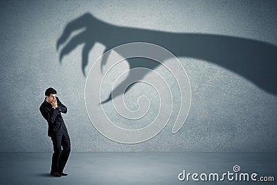 Business person afraid of a big monster claw shadow concept Stock Photo