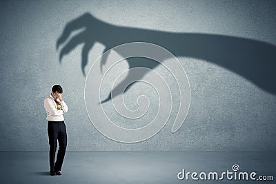 Business person afraid of a big monster claw shadow concept Stock Photo