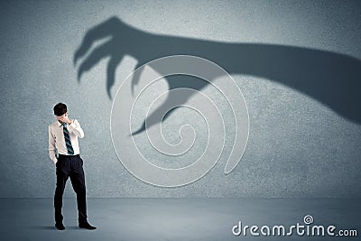 Business person afraid of a big monster claw shadow concept Stock Photo