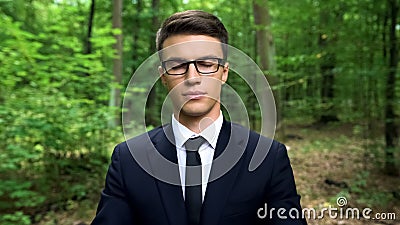 Business person feeling inner harmony in forest, finding body and mind balance Stock Photo