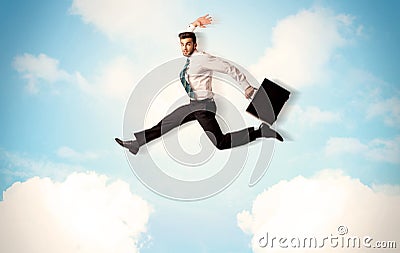 Business person jumping over clouds in the sky Stock Photo