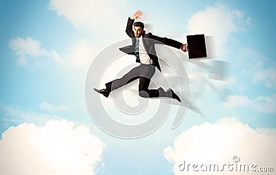 Business person jumping over clouds in the sky Stock Photo