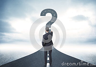 Business person lokking at road with question mark sign Stock Photo