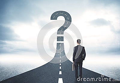 Business person lokking at road with question mark sign Stock Photo