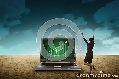 Business person looking giant laptop on the desert Stock Photo