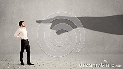 Business person looking at huge shadow hand pointing at him concept Stock Photo