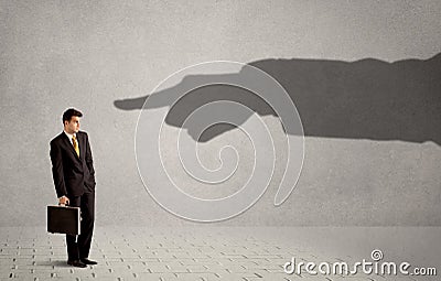 Business person looking at huge shadow hand pointing at him concept Stock Photo