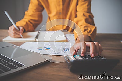 Business person sitting at a desk at an office By using the calculator to work. Business Concept Analysis and Planning Editorial Stock Photo