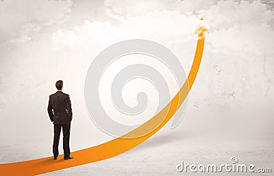 Business person standing on orange arrow Stock Photo