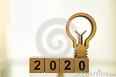2020 Business, Planning and Idea Concept. Close up of wooden number blocks with wood light bulb icon diecut with copy space Stock Photo
