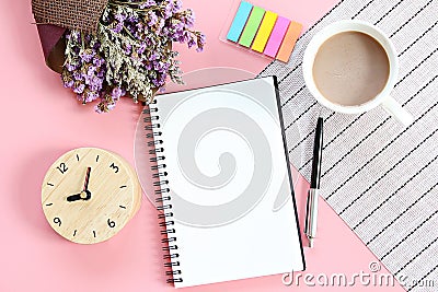 Top view or flat lay of open notebook paper, bouquet of dried wild flowers, clock, coffee cup on desk table Stock Photo