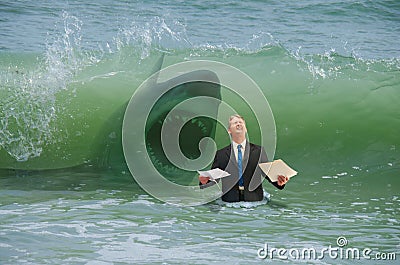 Business pressure man getting hit by wave with attacking shark Stock Photo