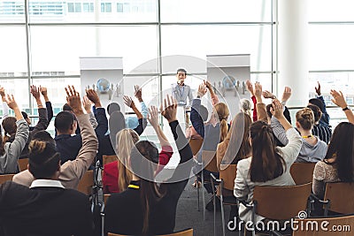 Business professionals raising hands in a business seminar Stock Photo