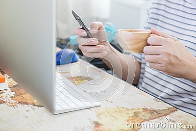 Business, Relax, Technology, Work from home Concept. Businessman holding and using mobile smartphone and holding a wooden mug cup Stock Photo