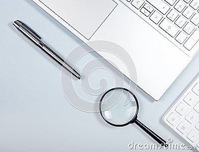 Business research and information technology concept. Laptop, magnifier, pen and calculator Stock Photo