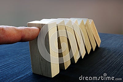 Business risk management concept. Hand holding blocks from falling. Domino effect. Stock Photo