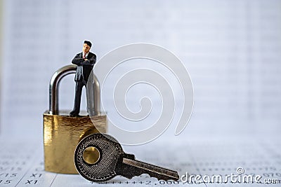 Business and Security Concept. Businessman miniature figure people standing on gold master key lock with silver key on bank Stock Photo