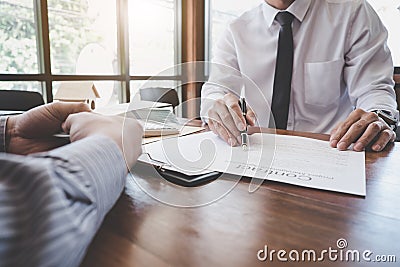 Business Signing a Contract Buy - sell house, Man sign a home insurance policy on home loans, insurance agent analyzing about home Stock Photo