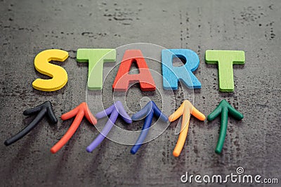 Business start or begin new life journey concept, colorful arrows point up to word START on blackboard cement wall Stock Photo